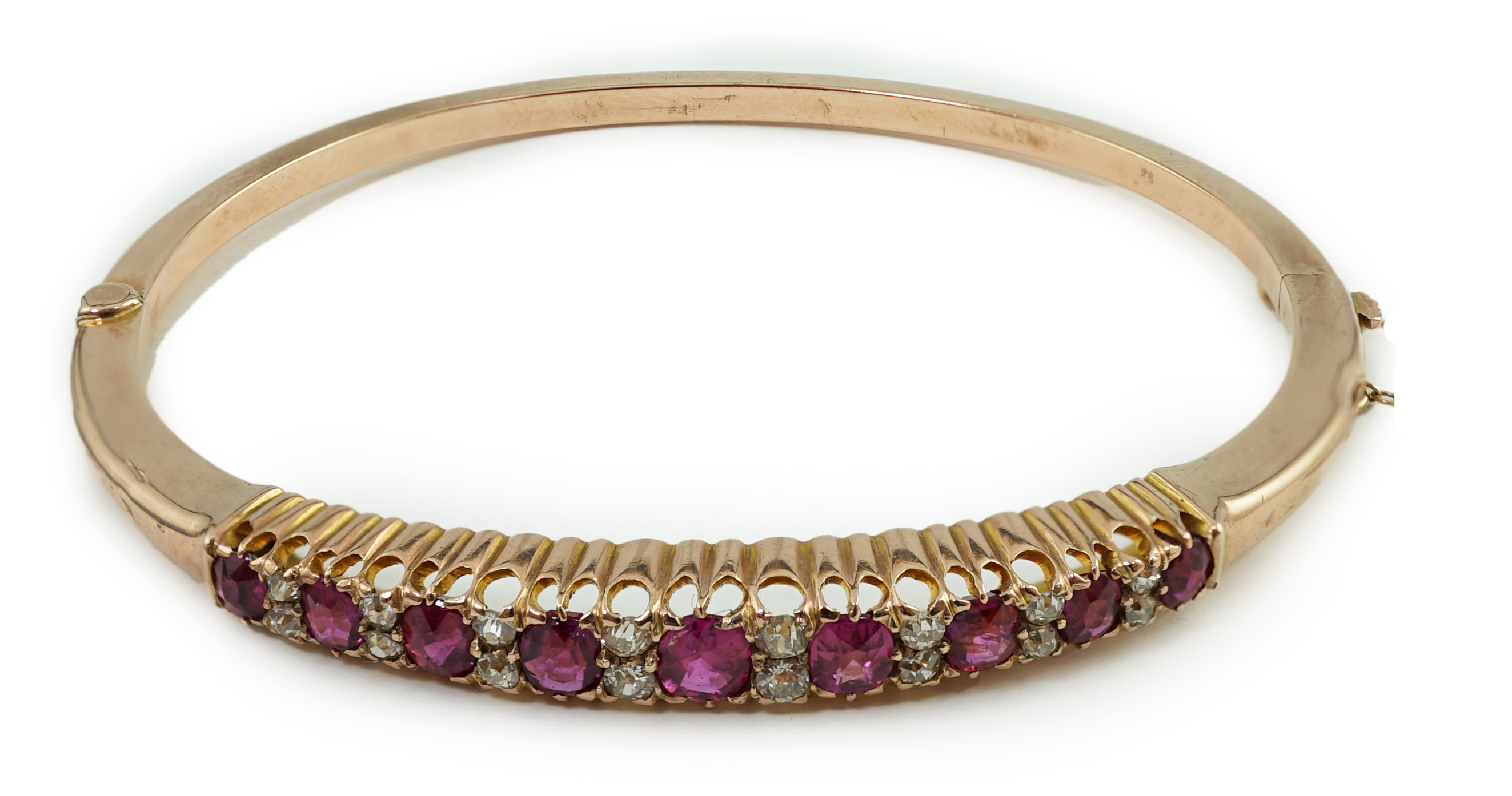 An Edwardian style gold, ruby and diamond cluster set hinged bangle